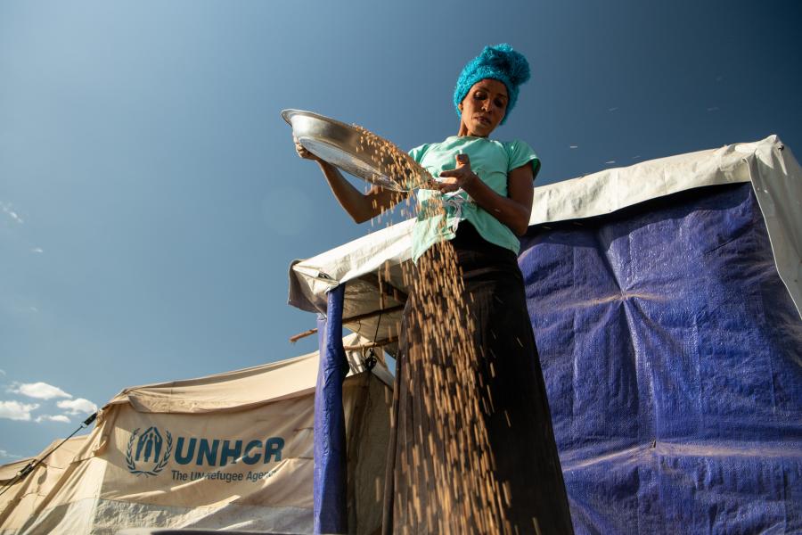 woman in refugee site sifting cereals